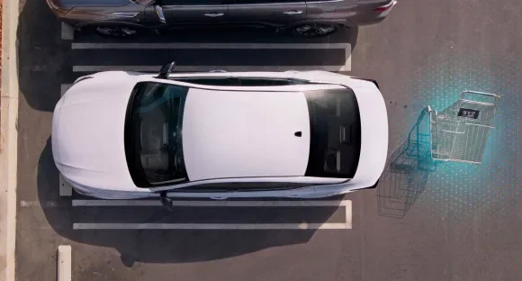 Top view of a white 2027 Nissan Altima in a parking lot with rear sensors detecting a shopping cart behind it at Holler Nissan Lexington in Lexington SC